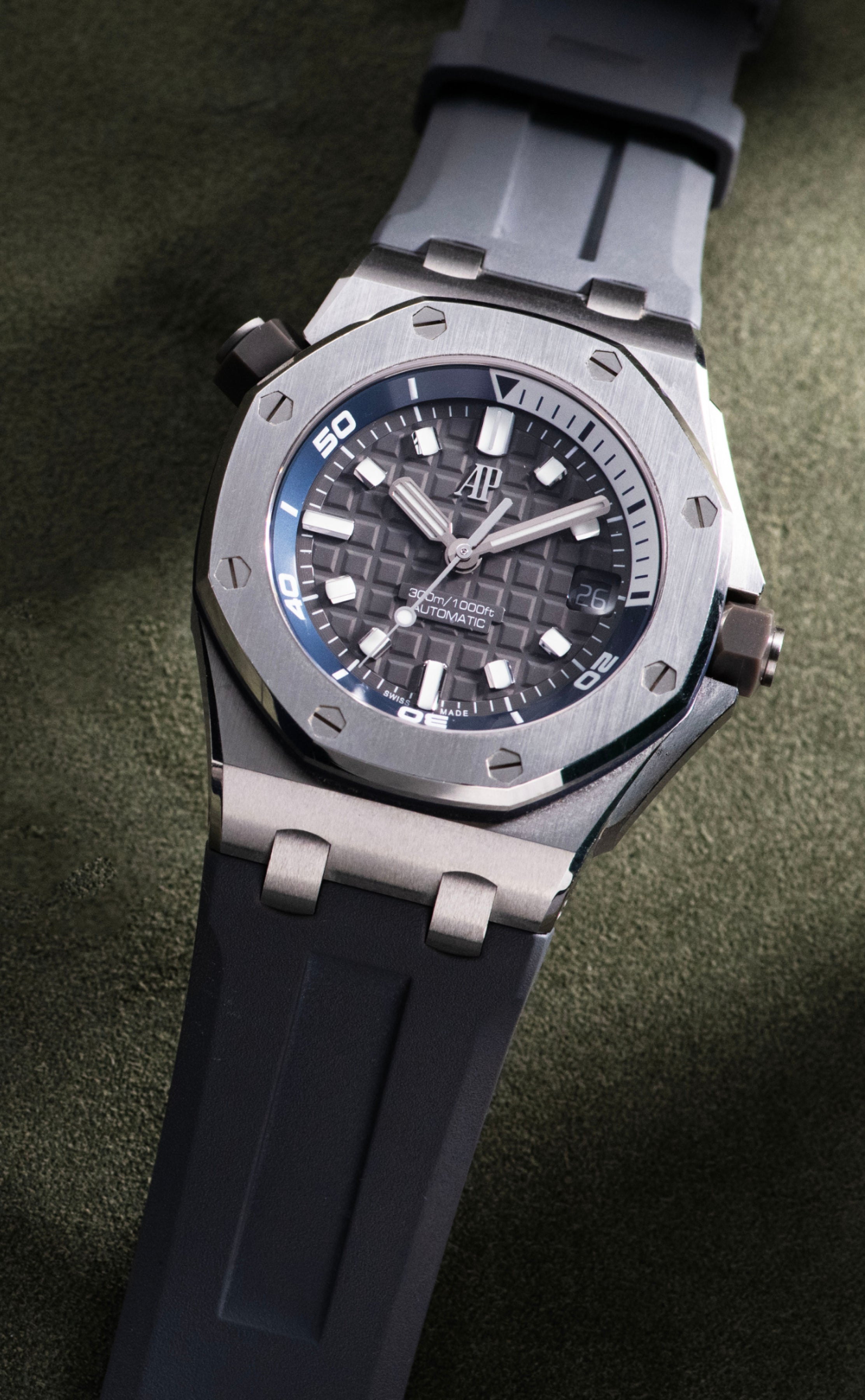Audemars Piguet Royal Oak Offshore Diver in stainless steel with a grey Méga Tapisserie dial, blue inner rotating bezel, date display and grey rubber strap.


10:54