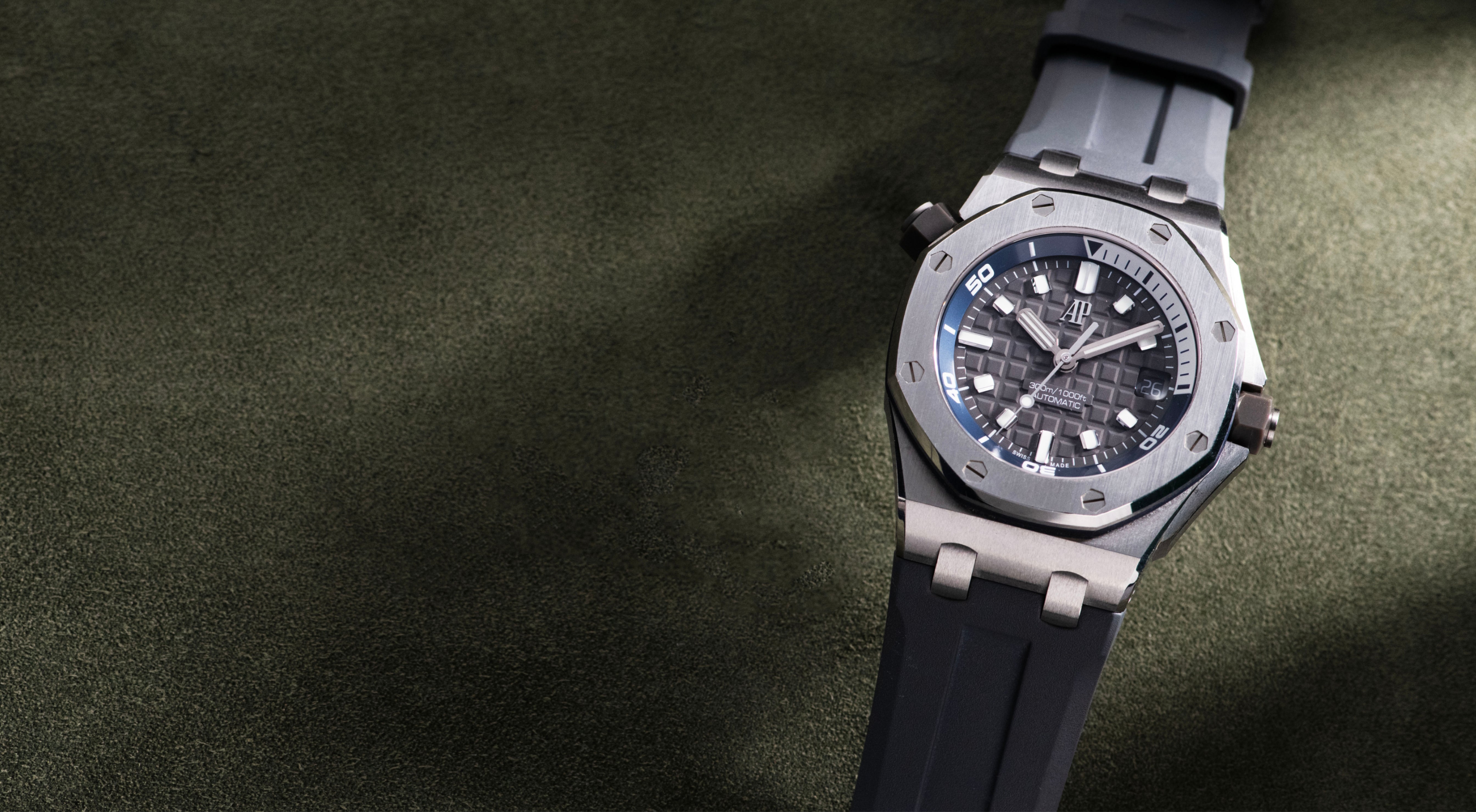 Audemars Piguet Royal Oak Offshore Diver in stainless steel with a grey Méga Tapisserie dial, blue inner rotating bezel, date display and grey rubber strap.