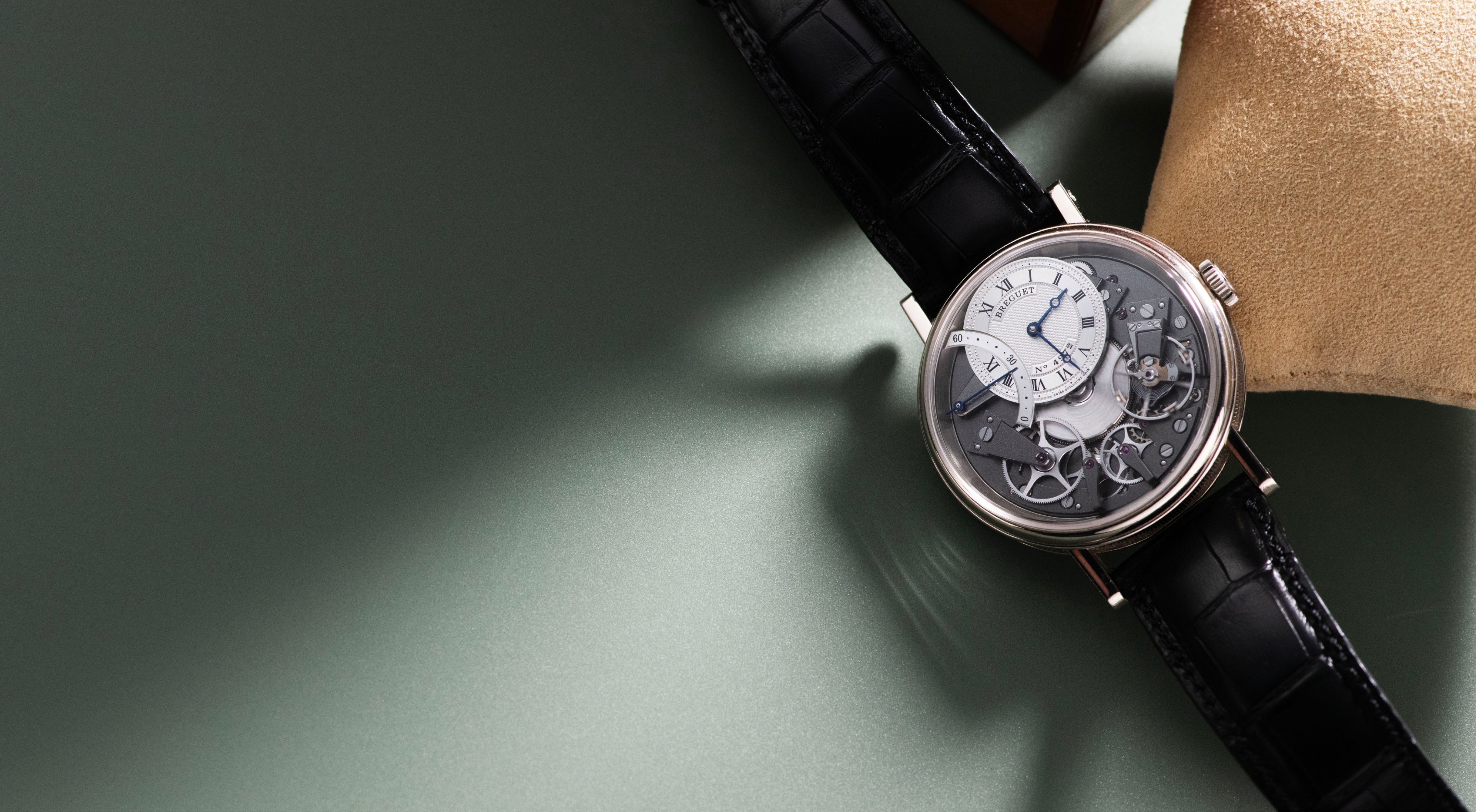 Breguet Tradition Automatique Seconde Rétrograde 7097 in white gold, featuring an exposed anthracite movement, off-centre silver guilloché dial, blued hands, retrograde seconds display and black alligator strap.