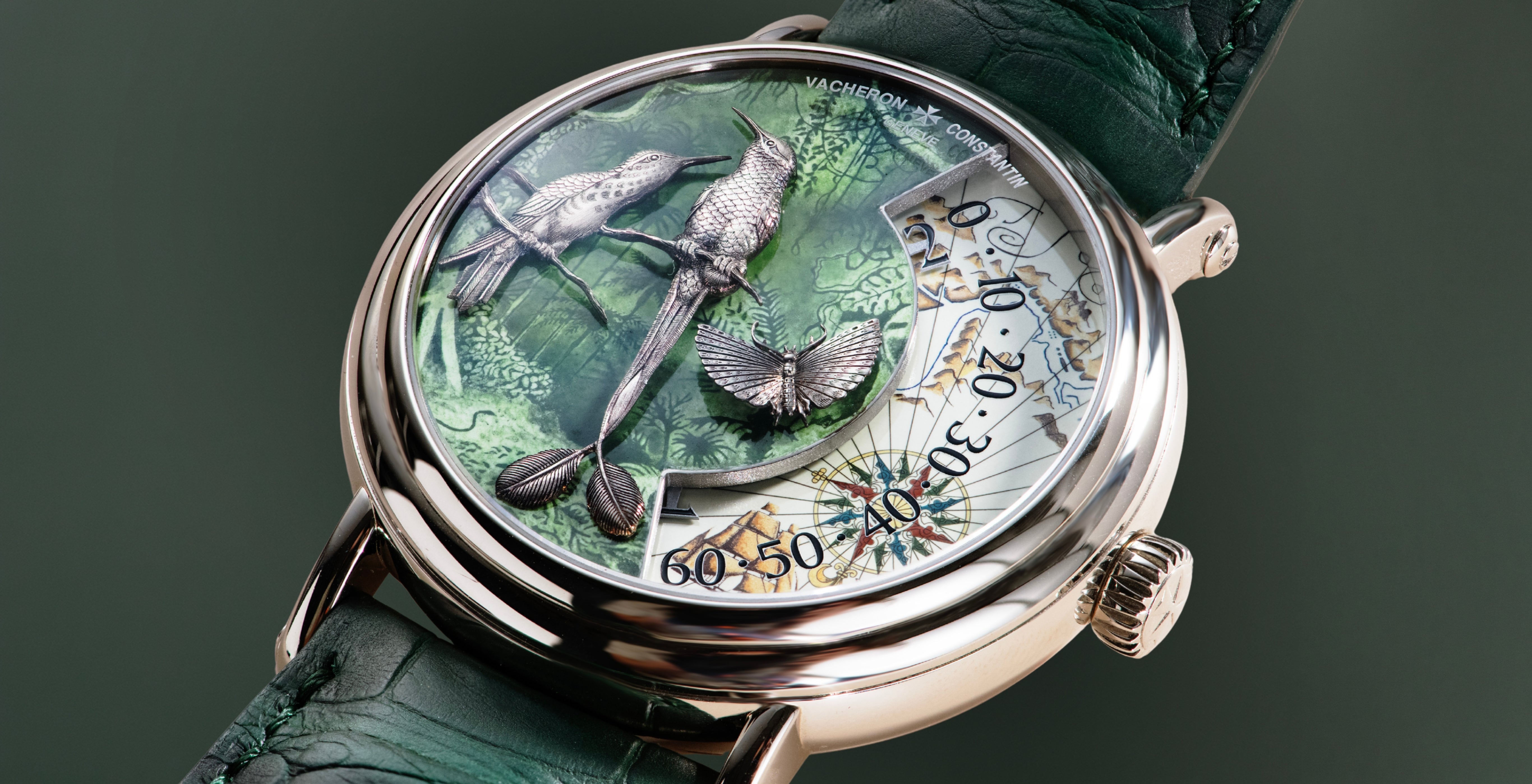 Close-up of the Vacheron Constantin Métiers d’Art Terre de Feu, featuring hand-engraved white-gold birds and a butterfly over a green enamel map dial with a wandering-hours display.